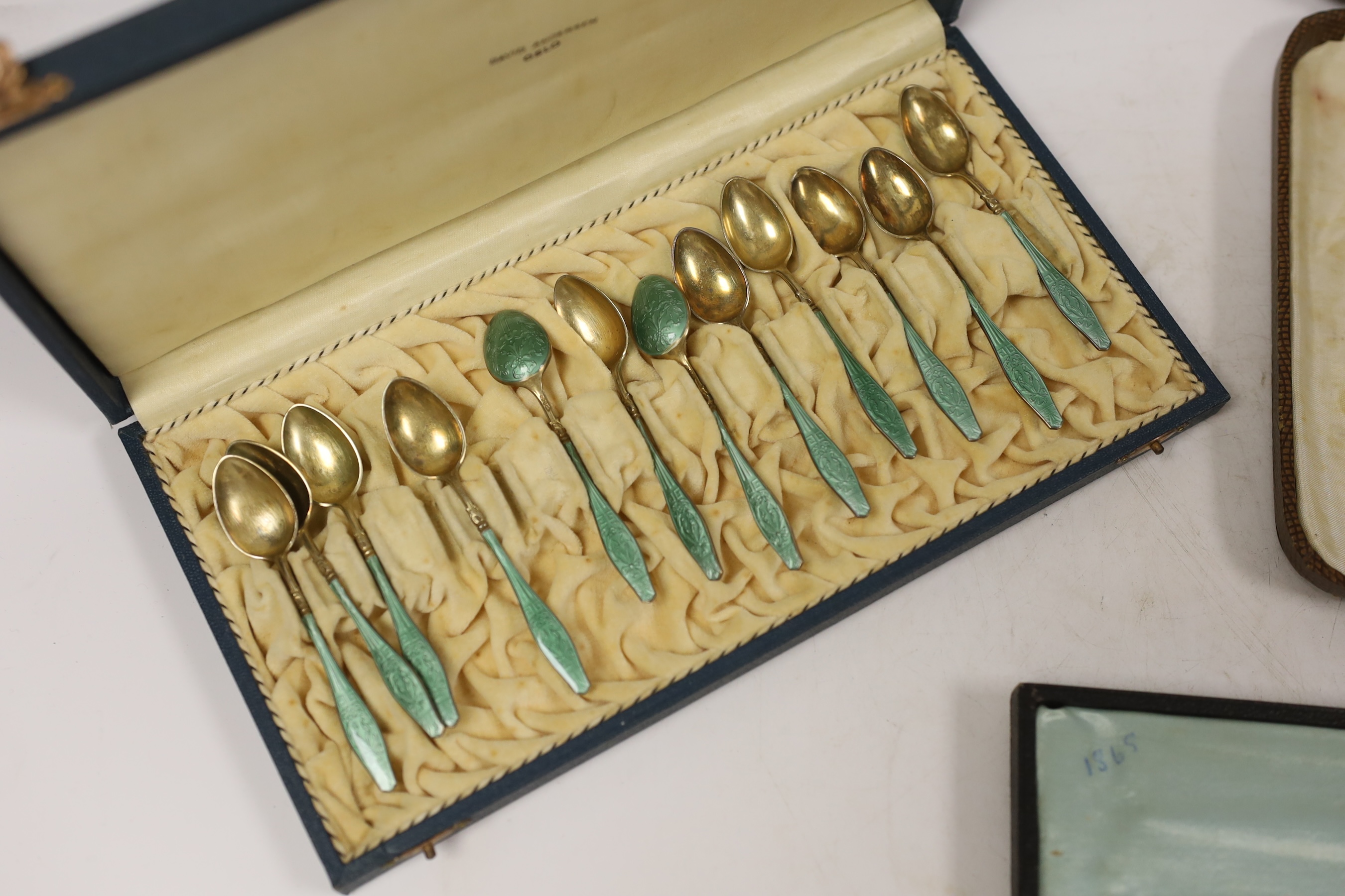 Four assorted cased cutlery sets including a set of twelve Norwegian gilt 925 and guilloche enamel coffee spoons.